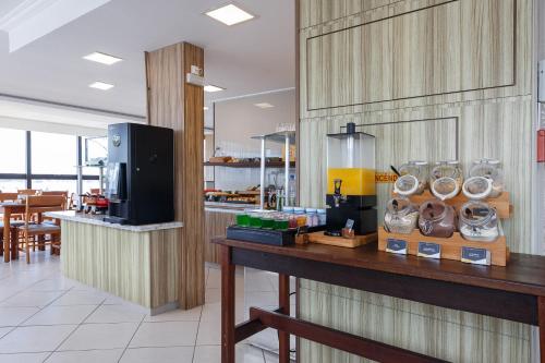 a restaurant with a counter with a coffee maker on it at Slim São José Zion in São José