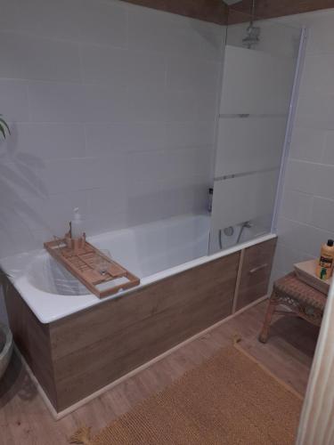 a bathroom with a bath tub with a table and a stool at chambre du jura in Saint-Germain-lès-Arlay