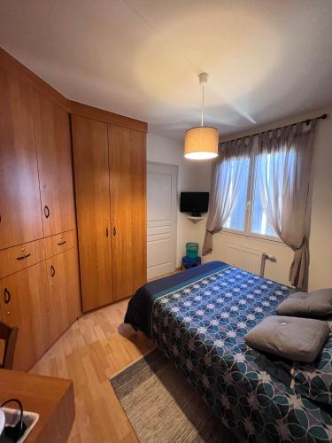 a bedroom with a bed and a large window at La Chambre des Amis in Parthenay