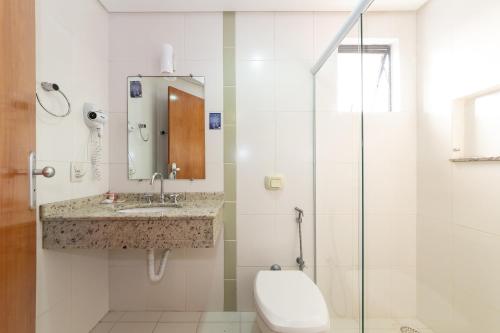 a bathroom with a toilet and a sink and a shower at Slim São José Zion in São José