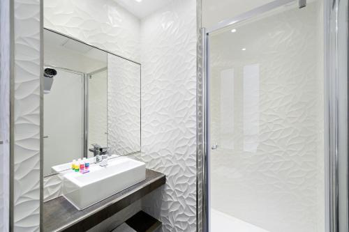 un baño con lavabo y espejo en Jardins de Montmartre, en París