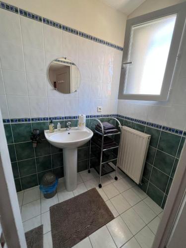 a bathroom with a sink and a mirror at La Chambre des Amis in Parthenay