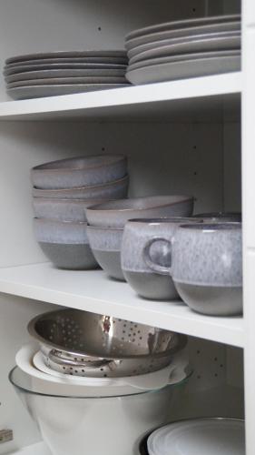 a shelf filled with plates and bowls and dishes at F&E - gemütliche & zentrumsnahe Unterkunft in Esslingen
