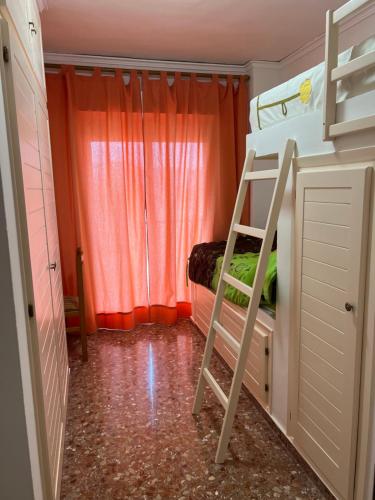 a bunk bed with a ladder in a small room at Casa Conxin Beach & Mountain Apartment Costa Blanca in Pego