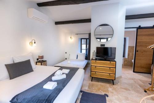 1 dormitorio con 1 cama blanca grande y TV en Longue Vie à la Reine - Piscine - Château, en Carcassonne