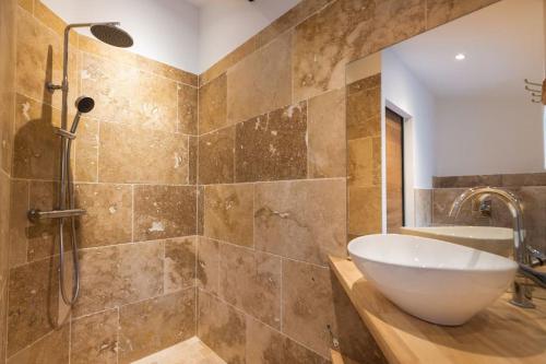 y baño con bañera, lavamanos y ducha. en Longue Vie à la Reine - Piscine - Château, en Carcassonne