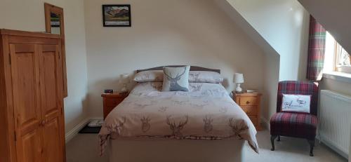 1 dormitorio con 1 cama y 1 silla en Beechwood Cottage B&B, en Glencoe