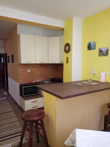 a kitchen with yellow and white cabinets and a counter at Apartman Balta in Pale