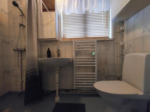 uma casa de banho com um lavatório, um WC e uma janela. em Buskbacken Logi em Bollnäs