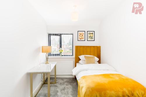 um pequeno quarto com uma cama e uma mesa em Birmingham 4 Bedroom Home - Driveway & Garden - Brand New! em Birmingham