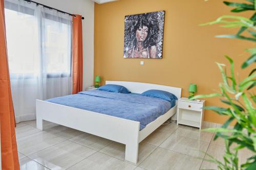 - une chambre avec un lit et une peinture murale dans l'établissement Ravissant appartement 2ch à la plage, à Pointe-Noire