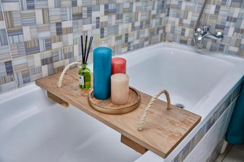 baño con bañera y bandeja de madera con velas en Ravissant appartement 2ch à la plage en Pointe-Noire