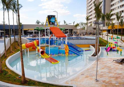 a pool with a water park with a slide at Apartamento dentro de resort próximo do Thermas dos Laranjais in Olímpia