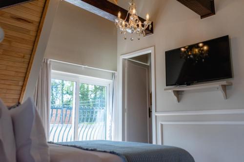 um quarto com uma cama e uma televisão de ecrã plano em Castelo Boutique Hotel em Fraiburgo