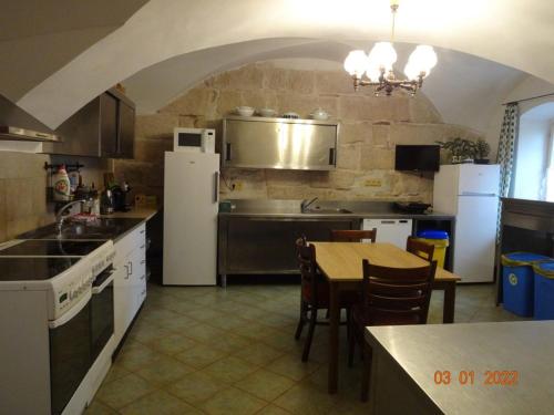 a kitchen with a table and a white refrigerator at Chalupa-statek Arkáda in Božanov