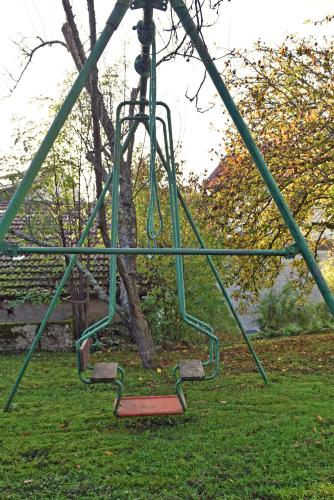 a swing set in a park with a tree at Maison à la campagne entre Nancy et Pont-à-Mousson in Malleloy