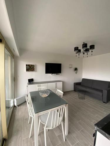 un salon avec une table, des chaises et un canapé dans l'établissement Superbe appartement rénové à neuf à 100m de la mer, à Juan-les-Pins