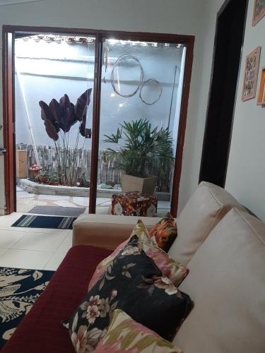 een woonkamer met een bank en een groot raam bij Casamatta Hostel in Pirenópolis