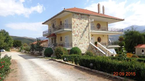 a house on a dirt road next to a driveway at VALIA ROOMS in Kalavrita