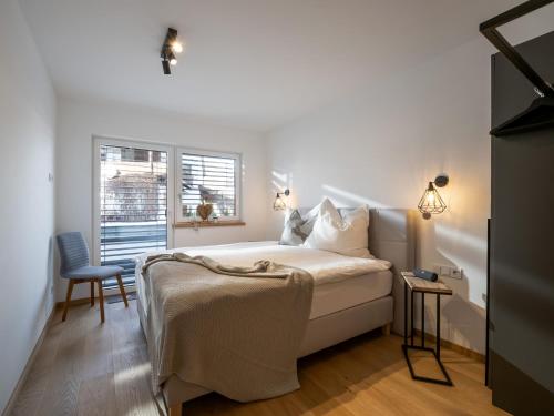 sypialnia z łóżkiem, krzesłem i oknem w obiekcie Ferienwohnung Tirolglück mit großem Garten w mieście Sankt Johann in Tirol