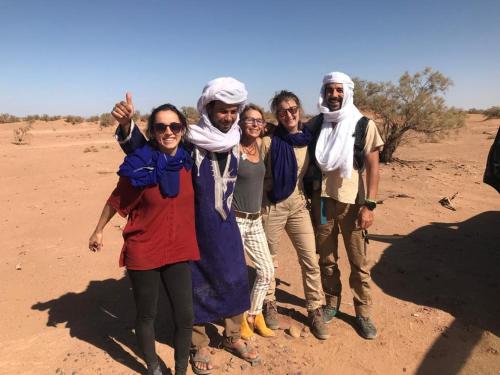 a group of people posing for a picture in the desert at Erg Chegaga Camp & Activites in Mhamid
