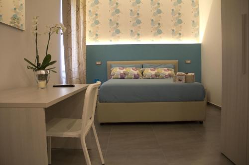 - une chambre avec un lit, une table et un bureau dans l'établissement Happy Home, à Fiumicino