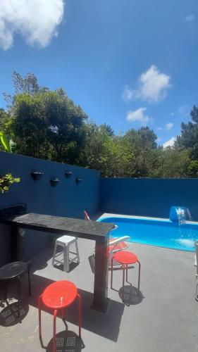 una mesa y cuatro sillas junto a una piscina en Casa nos ingleses, en Florianópolis