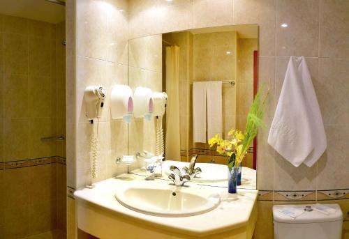 a bathroom with a sink and a mirror and a toilet at Aqua Hotel in Varna City