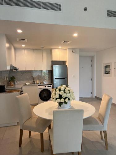 a kitchen with a table with a vase of flowers on it at MJL Rahaal2- 301Apartament in Dubai