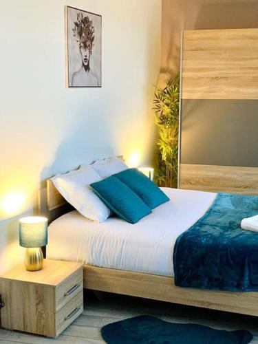 a bedroom with a bed with blue and white pillows at TOUR de l’europe, en plein centre avec parking. in Mulhouse