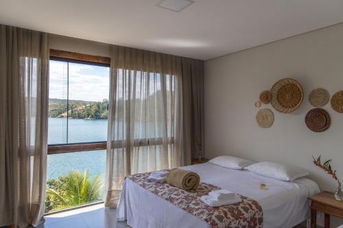 una camera da letto con un letto e una grande finestra di Pousada Piratas do Barro Branco a Pedregulho