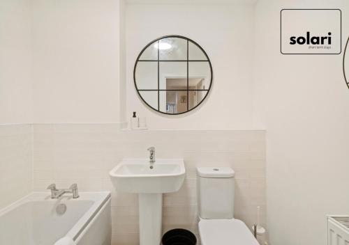 a white bathroom with a sink and a mirror at Lux 4 Bed Contractor x Relocator Apartment, 30 Percent Off Monthly Stays, FREE Multiple Parking Spaces, Super Fast WiFi, Streaming Services included, Close to A1 in Peterborough