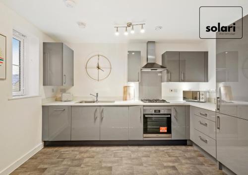 a kitchen with white cabinets and a stove top oven at Lavish 2-Bedrooms - Contractors and Relocators Apartment, 30-Percent-Off on Monthly Stays - Free Multiple Parking Spaces - Guest 4 - Fast Speed Wi-Fi, Streaming Services included - Close to A1 in Peterborough