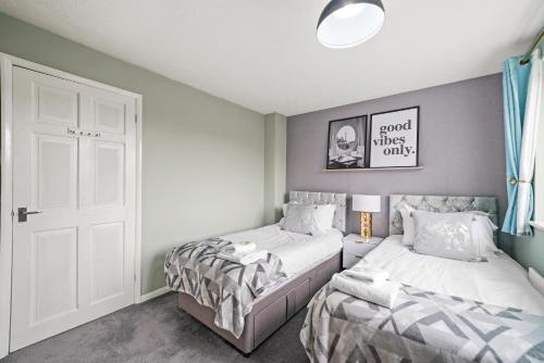 sypialnia z 2 łóżkami i białymi drzwiami w obiekcie Welcoming House with Large Driveway, Private Garden, Fast Wifi and Smart TV by Yoko Property w mieście Northampton
