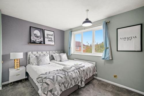 um quarto com uma cama e uma janela em Welcoming House with Large Driveway, Private Garden, Fast Wifi and Smart TV by Yoko Property em Northampton