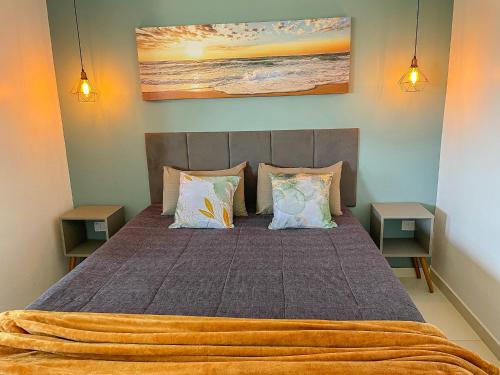 a bedroom with a large bed with two tables at Mangata Loft - Requinte e Conforto para Lazer ou Trabalho in Itanhaém
