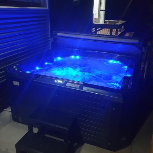 a hot tub with blue lights in a room at Mountain Glass - Ohakune Holiday Home in Ohakune