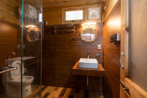 a bathroom with a sink and a glass shower at Wolfandwoods in Khajjiar 