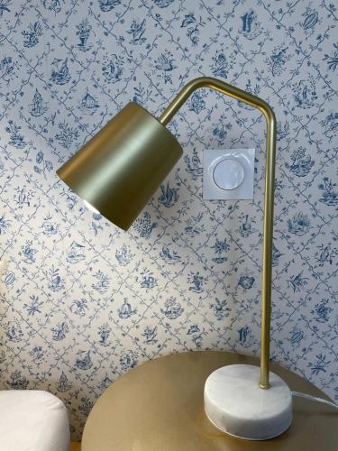 une lampe dans une pièce avec papier peint bleu et blanc dans l'établissement Le Marin, à 500m du centre ville, à Dax