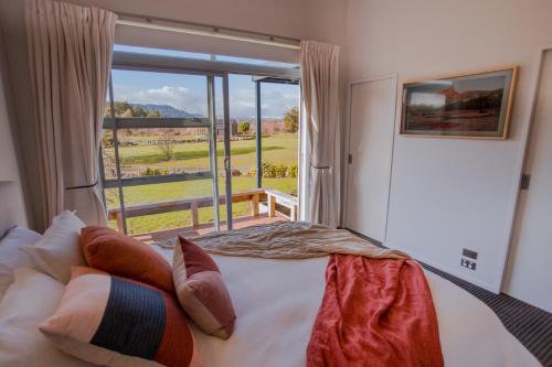 a bedroom with a bed and a large window at Mountain Glass - Ohakune Holiday Home in Ohakune