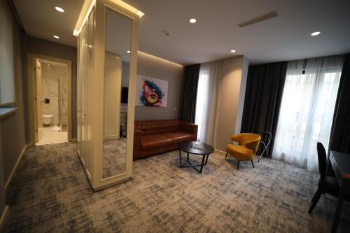 ein Wohnzimmer mit einem Sofa, einem Tisch und einem Spiegel in der Unterkunft H41 Luxury Suites in Belgrad