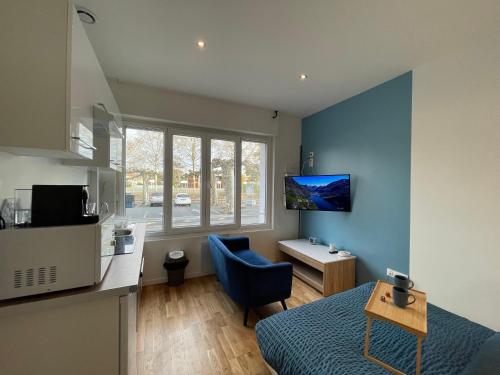 a small room with a bed and a blue wall at Le Marin, à 500m du centre ville in Dax