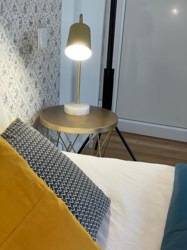 a bedroom with a bed and a table with a lamp at Le Marin, à 500m du centre ville in Dax