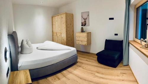 a bedroom with a bed and a blue chair at Apart Smart in Bruck am Ziller