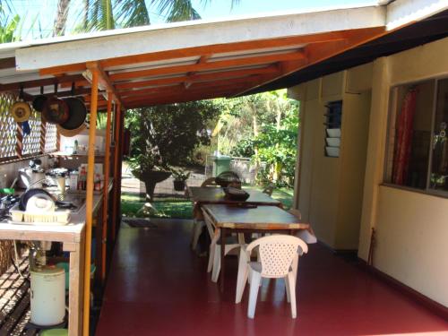 a patio with a table and chairs on a house at Pension TE MITI - PLAGE-BEACH 200m - Mahana Parc & Vaiava Beach pk18 - B&B CHAMBRES ou DORTOIR in Punaauia