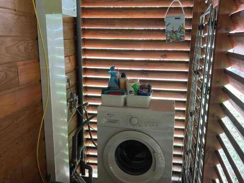 een wasmachine en droger in een kamer met een raam bij La kaz à pépés, charmant logement avec piscine in Lamentin