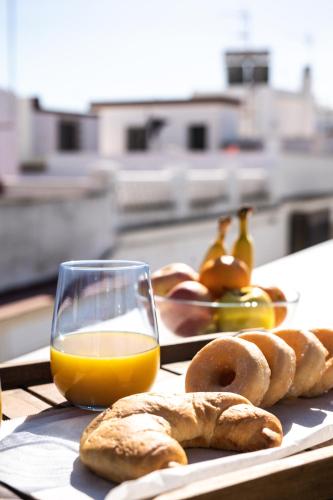 Un vaso de jugo de naranja y algunos bagels en una mesa. en Prim 14 by 7Escalones, en Rota
