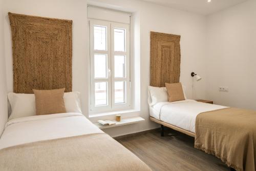 a bedroom with two beds and a window at Prim 14 by 7Escalones in Rota