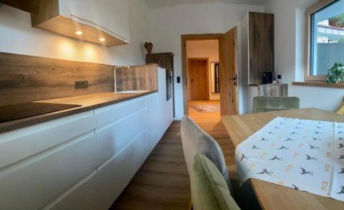 a kitchen with a wooden table and a dining room at Apart Smart in Bruck am Ziller