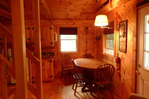 una sala da pranzo con tavolo e sedie in una cabina di Wild Fox Cabins a The Pines